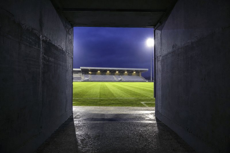 Il tunnel dei giocatori che si apre su un campo illuminato – immagine generata con AI.